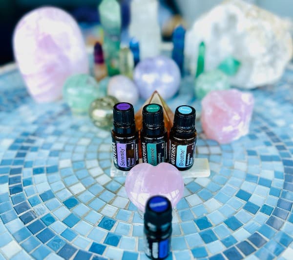 DoTERRA essential oils and healing crystals on a mosaic table