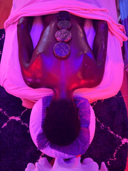 Hot stone massage treatment with healing crystals under ambient lighting