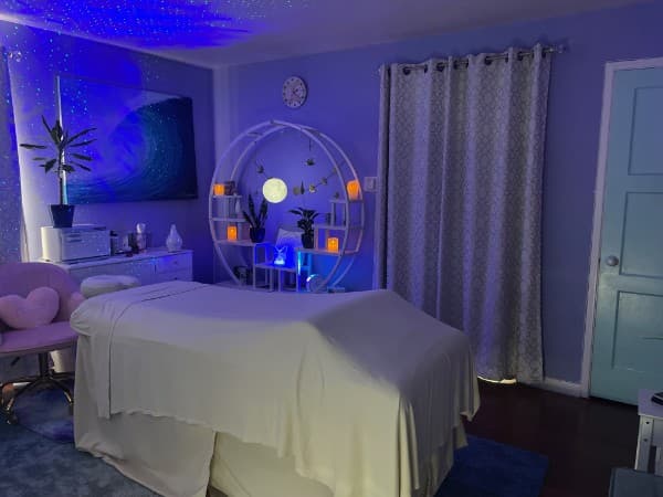 Treatment room with calming blue ambient lighting and ocean wave artwork