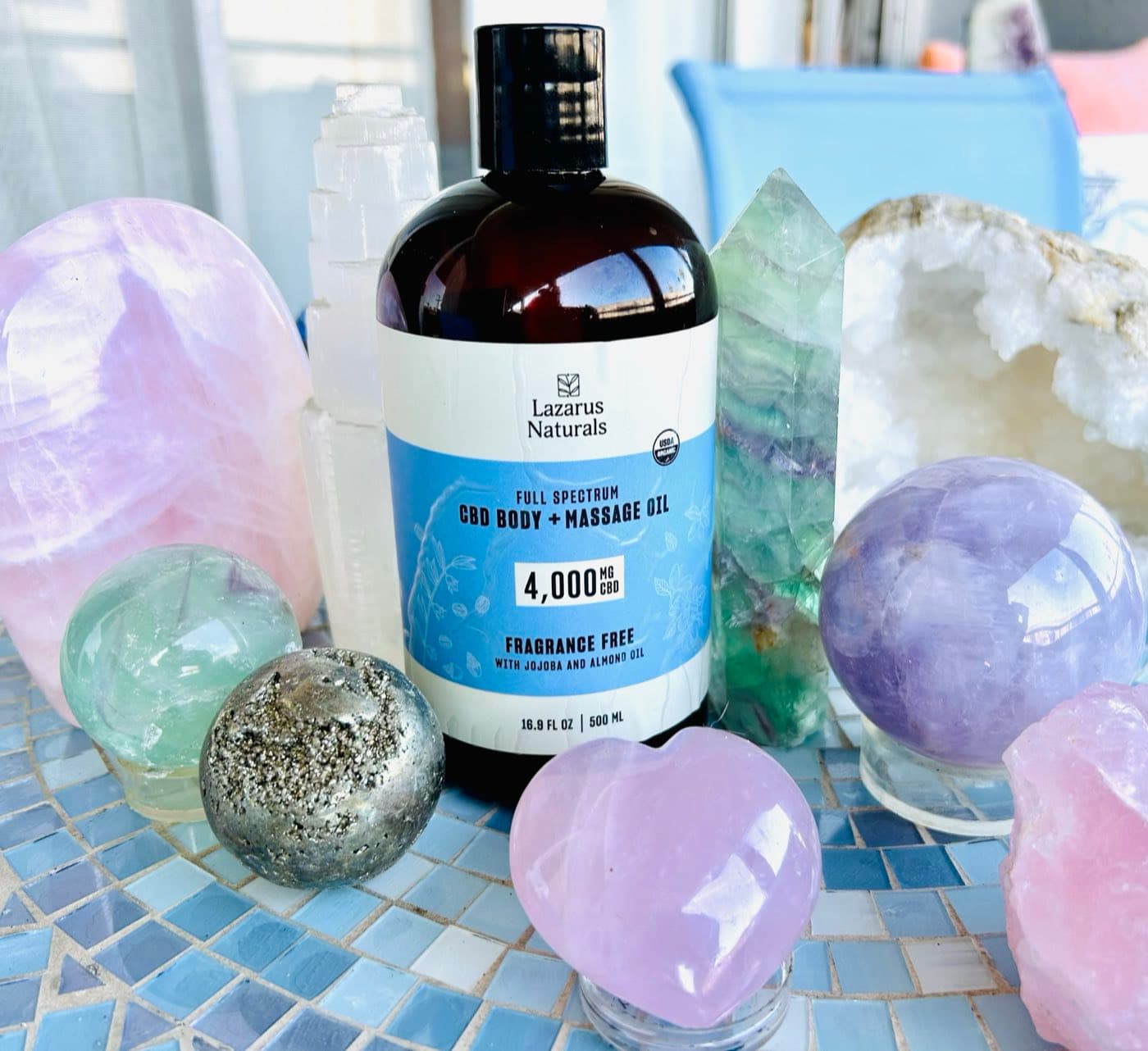 CBD massage oil surrounded by rose quartz and fluorite crystals